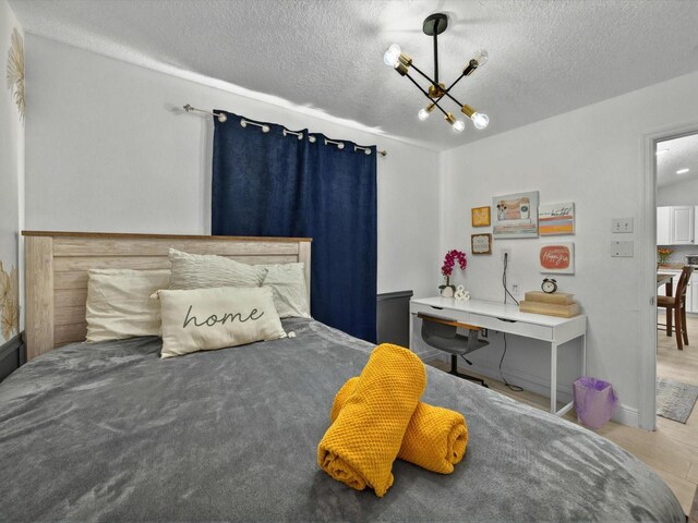 703 Sunridge Woods Blvd, Davenport, FL 33837 - bedroom with a textured ceiling and a chandelier