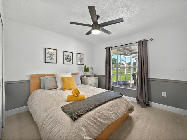 703 Sunridge Woods Blvd, Davenport, FL 33837 - bedroom with wood finished floors, a textured ceiling, baseboards, and ceiling fan
