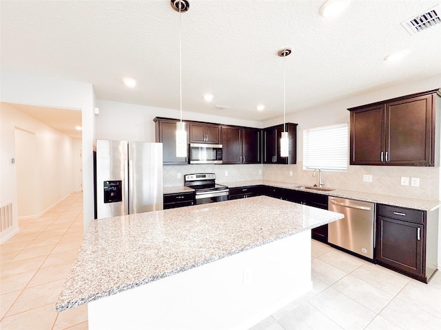 398 Citrus Isle Loop, Davenport, FL 33837 - kitchen featuring stainless steel appliances, a sink, a center island, dark brown cabinetry, and recessed lighting
