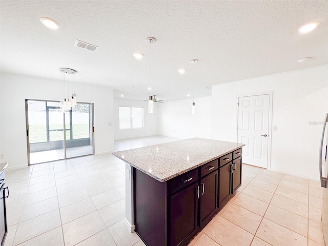 398 Citrus Isle Loop, Davenport, FL 33837 - kitchen featuring pendant lighting, a kitchen island, light stone countertops, light tile patterned floors, and open floor plan