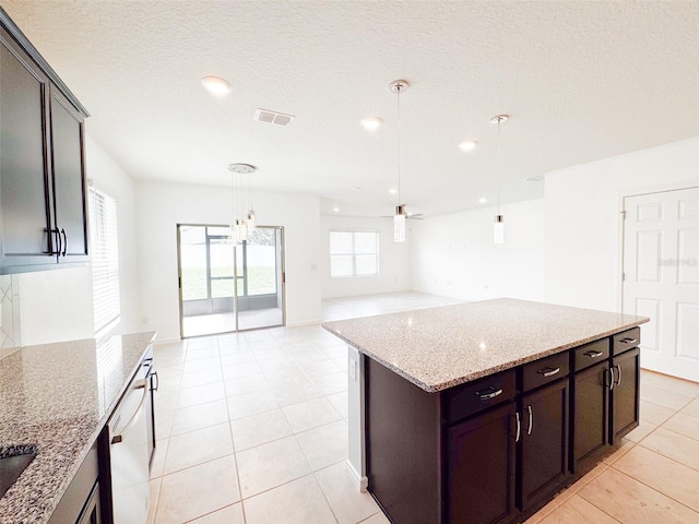 398 Citrus Isle Loop, Davenport, FL 33837 - kitchen with hanging light fixtures, light stone countertops, ceiling fan, light tile patterned floors, and open floor plan