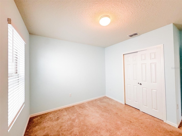 398 Citrus Isle Loop, Davenport, FL 33837 - unfurnished bedroom featuring light carpet, a closet, baseboards, and a textured ceiling
