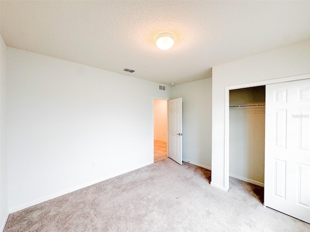 398 Citrus Isle Loop, Davenport, FL 33837 - unfurnished bedroom with light carpet, a closet, baseboards, and a textured ceiling