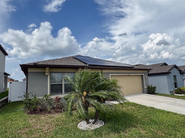398 Citrus Isle Loop, Davenport, FL 33837 - view of front of home with driveway, solar panels, stucco siding, a garage, and a front lawn
