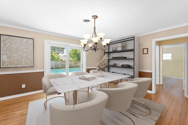 2020 Geronimo Trl, Maitland, FL 32751 - dining area with a chandelier, baseboards, plenty of natural light, light wood-style flooring, and crown molding