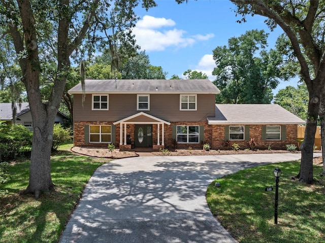 120 Springwood Trl, Altamonte Springs, FL 32714 - traditional home with brick siding, a front lawn, curved driveway, and covered porch