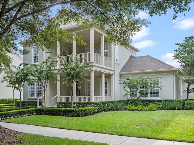 1438 Stickley Ave, Celebration, FL 34747 - view of front of property featuring a balcony, a porch, stucco siding, a front lawn, and a shingled roof