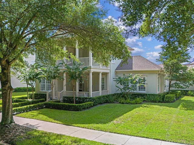 1438 Stickley Ave, Celebration, FL 34747 - view of front of property with a balcony, covered porch, stucco siding, and a front lawn