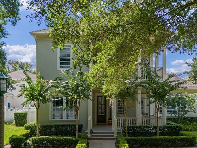 1438 Stickley Ave, Celebration, FL 34747 - obstructed view of property with stucco siding, a porch, and a balcony