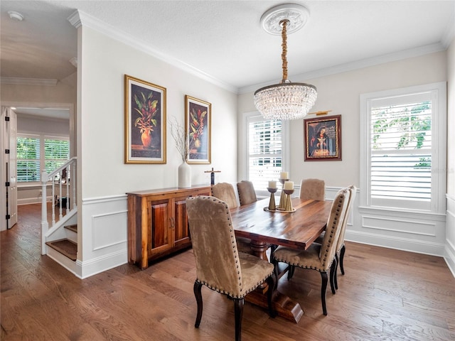 1438 Stickley Ave, Celebration, FL 34747 - dining room featuring a chandelier, wood finished floors, crown molding, a wainscoted wall, and a decorative wall