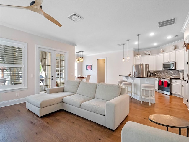 1438 Stickley Ave, Celebration, FL 34747 - living area with crown molding, a chandelier, light wood finished floors, a ceiling fan, and baseboards
