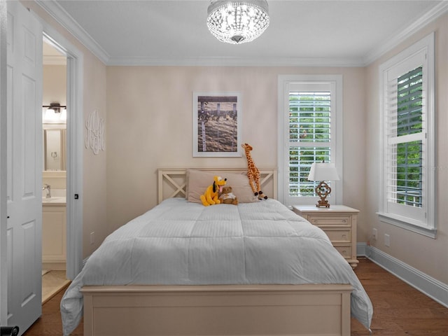 1438 Stickley Ave, Celebration, FL 34747 - bedroom featuring crown molding, dark wood-type flooring, ensuite bath, baseboards, and a chandelier