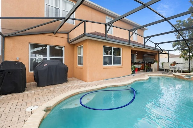 314 Edgewood Ct, Kissimmee, FL 34759 - view of swimming pool with a patio area, grilling area, glass enclosure, and a pool with connected hot tub