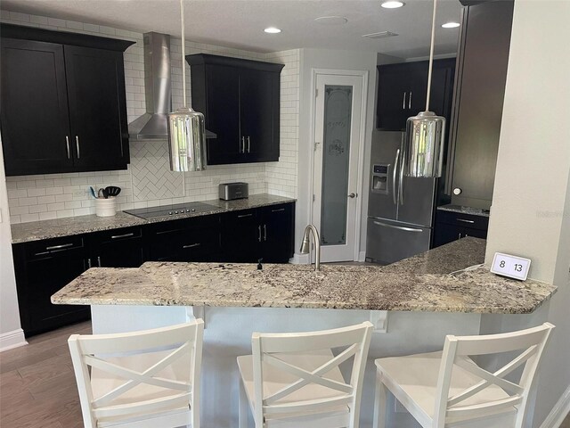 302 Coco Plum Ct, Oldsmar, FL 34677 - kitchen featuring stainless steel fridge, dark cabinetry, black electric cooktop, a kitchen bar, and recessed lighting