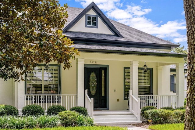 11721 Camden Park Dr, Windermere, FL 34786 - entrance to property with a porch, a shingled roof, and stucco siding
