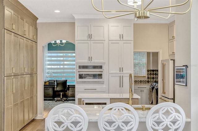 11721 Camden Park Dr, Windermere, FL 34786 - kitchen with oven, a chandelier, high end fridge, crown molding, and light countertops