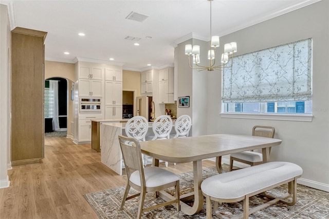 11721 Camden Park Dr, Windermere, FL 34786 - dining area with light wood-style floors, baseboards, ornamental molding, a chandelier, and arched walkways