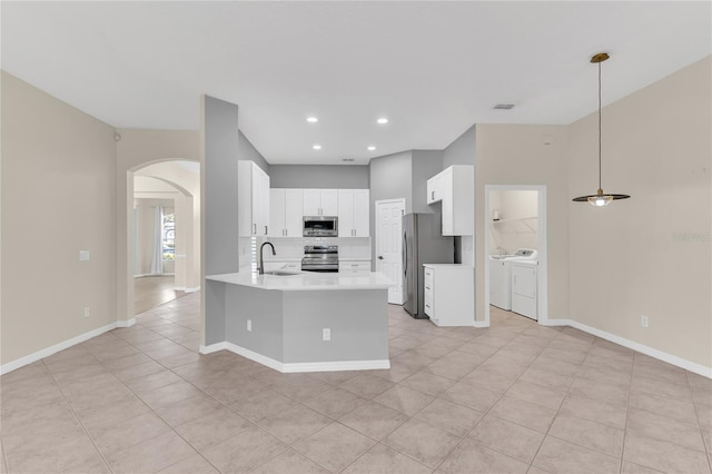10417 Oakview Pointe Ter, Gotha, FL 34734 - kitchen featuring stainless steel appliances, washer and dryer, a sink, arched walkways, and a peninsula