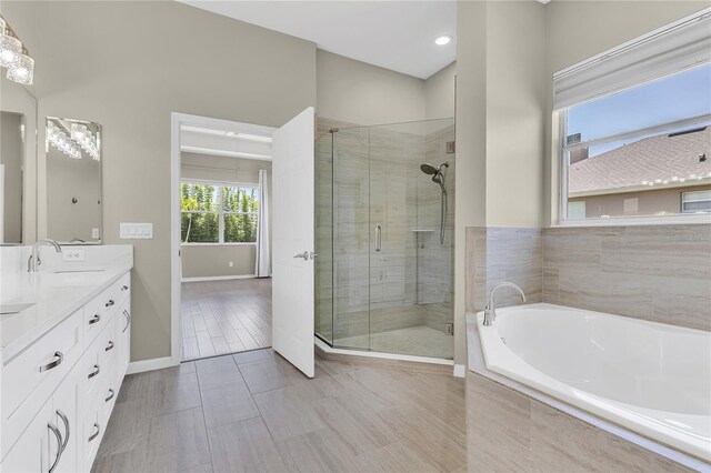 10417 Oakview Pointe Ter, Gotha, FL 34734 - bathroom featuring a bath, double vanity, a shower stall, and baseboards