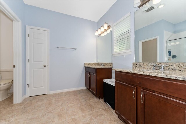 9348 Meadow Hunt Way, Winter Garden, FL 34787 - bathroom featuring a stall shower, two vanities, toilet, tile patterned floors, and baseboards