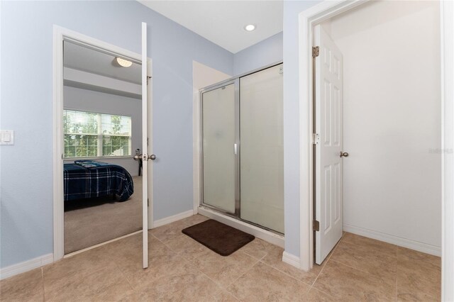 9348 Meadow Hunt Way, Winter Garden, FL 34787 - bathroom with a stall shower, ensuite bath, tile patterned floors, and baseboards