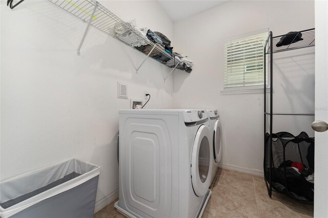 9348 Meadow Hunt Way, Winter Garden, FL 34787 - laundry room with washing machine and dryer, baseboards, and light tile patterned floors
