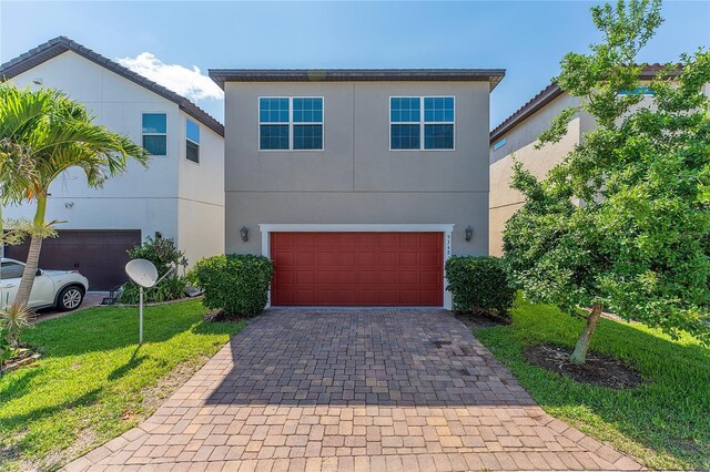 9348 Meadow Hunt Way, Winter Garden, FL 34787 - view of front of home featuring a garage, decorative driveway, a front lawn, and stucco siding