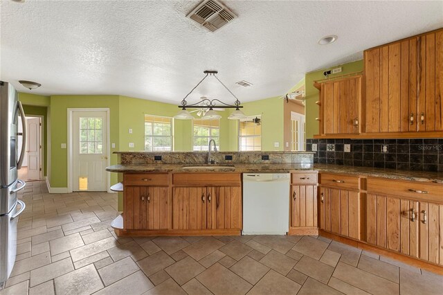 16017 Johns Lake Rd, Clermont, FL 34711 - kitchen featuring white dishwasher, a sink, a peninsula, brown cabinets, and stainless steel refrigerator with ice dispenser