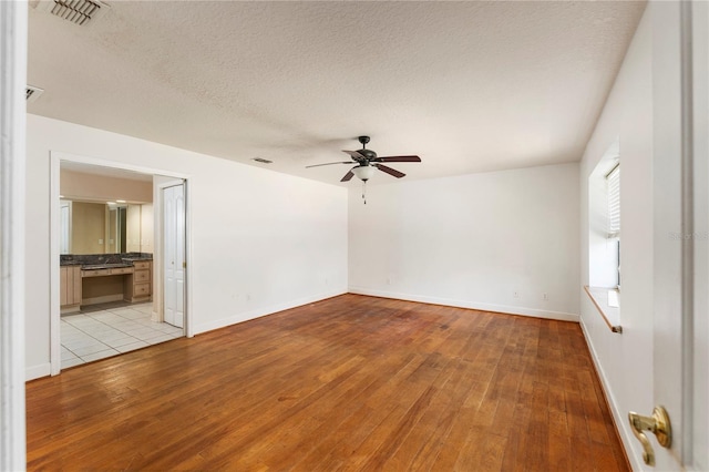 16017 Johns Lake Rd, Clermont, FL 34711 - empty room with light wood-style floors, ceiling fan, baseboards, and a textured ceiling