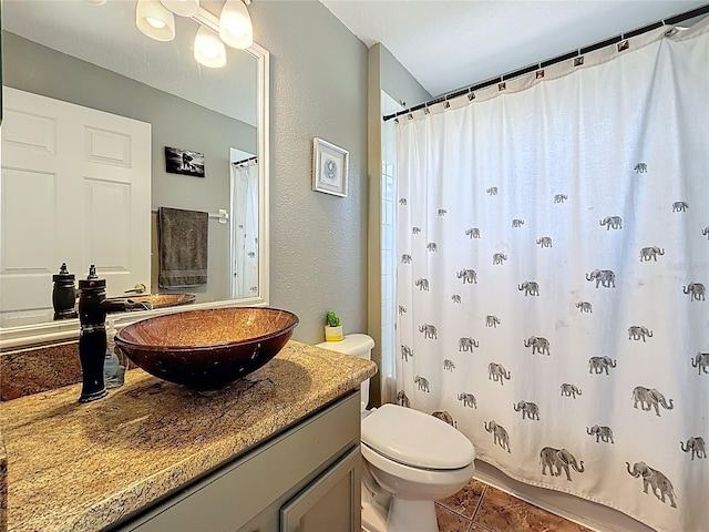 1913 Blue River Rd, Holiday, FL 34691 - bathroom with toilet, vanity, a textured wall, a shower with curtain, and tile patterned flooring