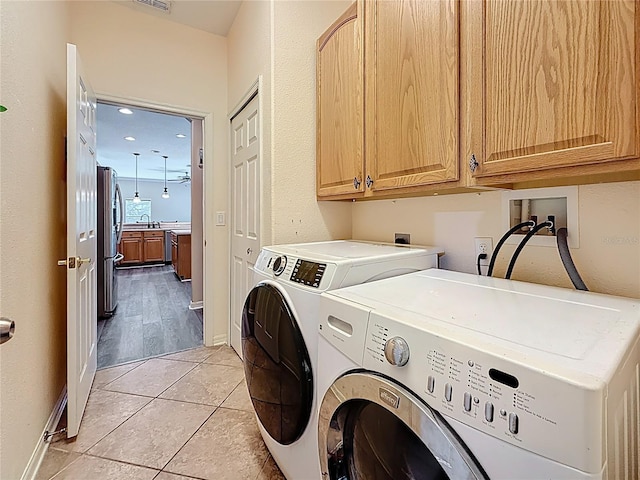 1913 Blue River Rd, Holiday, FL 34691 - laundry area featuring washer and dryer, cabinet space, light tile patterned floors, and baseboards