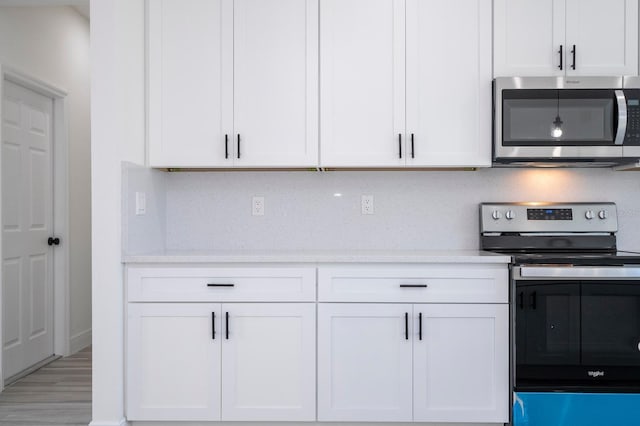 3211 SW 128th Street Rd, Ocala, FL 34473 - kitchen featuring stainless steel appliances, white cabinets, and light stone counters