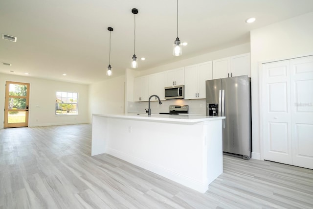 3211 SW 128th Street Rd, Ocala, FL 34473 - kitchen featuring stainless steel appliances, light wood-style floors, white cabinetry, baseboards, and light countertops