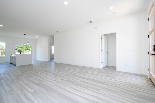 3211 SW 128th Street Rd, Ocala, FL 34473 - unfurnished living room featuring recessed lighting, light wood-style floors, baseboards, and a sink