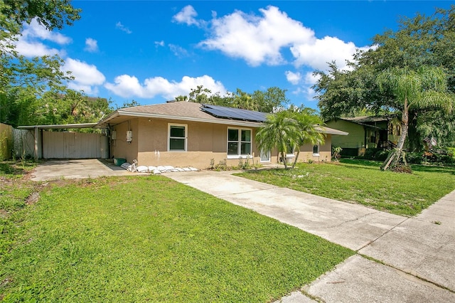 3431 Hunt Ln, Oviedo, FL 32765 - ranch-style house with stucco siding, a carport, solar panels, a front lawn, and concrete driveway