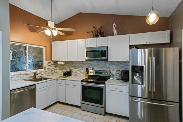 2916 Maldive Ct, Deltona, FL 32738 - kitchen featuring stainless steel appliances, lofted ceiling, light countertops, backsplash, and white cabinets