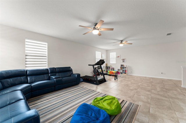 2401 Oxmoor Dr, Deland, FL 32724 - living room featuring a ceiling fan, light tile patterned floors, baseboards, and a textured ceiling