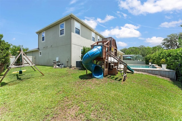 2401 Oxmoor Dr, Deland, FL 32724 - rear view of house featuring a playground, a yard, central air condition unit, stucco siding, and a swimming pool