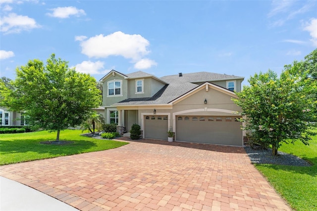 2401 Oxmoor Dr, Deland, FL 32724 - view of front of home with stucco siding, a front lawn, decorative driveway, a garage, and roof with shingles
