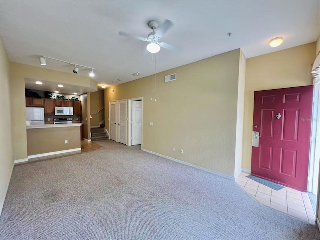 4010 Santa Maria Dr Unit 106, Kissimmee, FL 34741 - unfurnished living room featuring light carpet, ceiling fan, rail lighting, light tile patterned floors, and baseboards