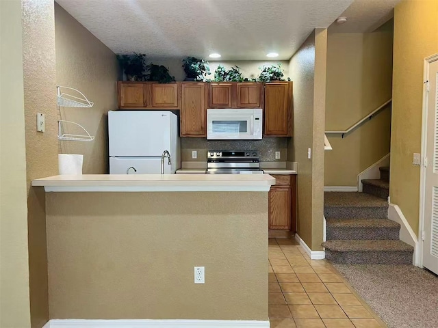 4010 Santa Maria Dr Unit 106, Kissimmee, FL 34741 - kitchen with white appliances, light tile patterned floors, brown cabinets, light countertops, and a sink