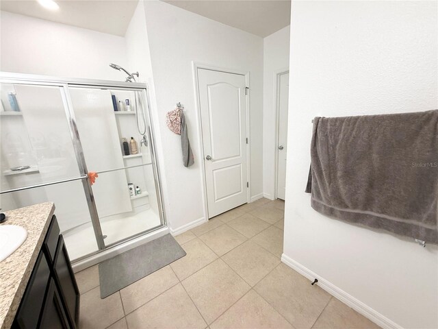 238 Miniehaha Cir, Haines City, FL 33844 - bathroom with a stall shower, baseboards, vanity, and tile patterned flooring