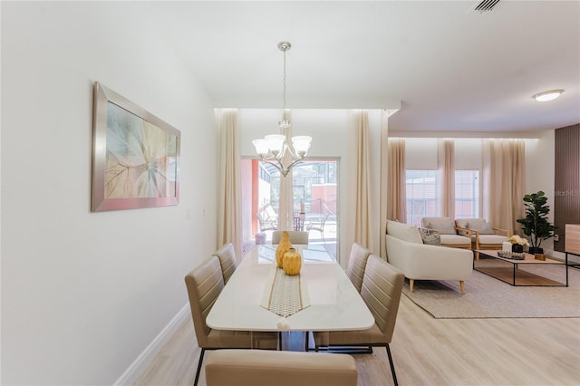 2923 Banana Palm Dr, Kissimmee, FL 34747 - dining space with light wood-style flooring, a chandelier, and baseboards