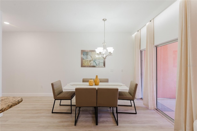 2923 Banana Palm Dr, Kissimmee, FL 34747 - dining area with a chandelier, light wood-style flooring, and baseboards