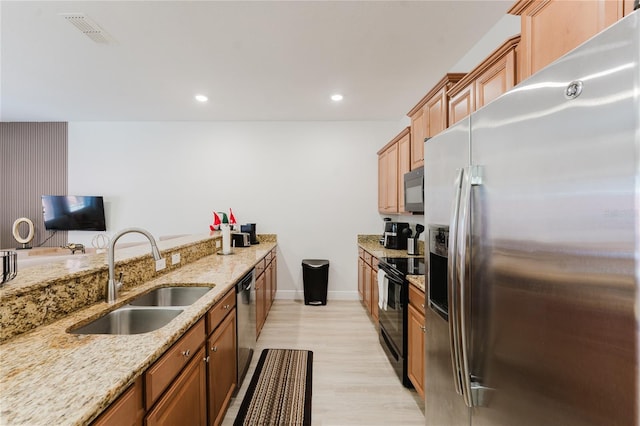 2923 Banana Palm Dr, Kissimmee, FL 34747 - kitchen featuring black appliances, a sink, light wood-type flooring, light stone countertops, and baseboards