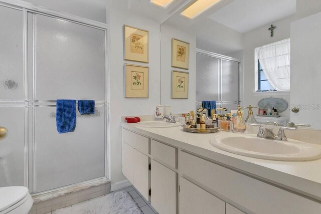 3501 Danby Ct, Orlando, FL 32812 - full bathroom featuring a stall shower, toilet, double vanity, and tile patterned floors