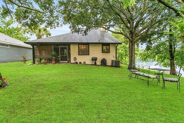 3501 Danby Ct, Orlando, FL 32812 - rear view of house featuring central air condition unit, a yard, stucco siding, and a water view