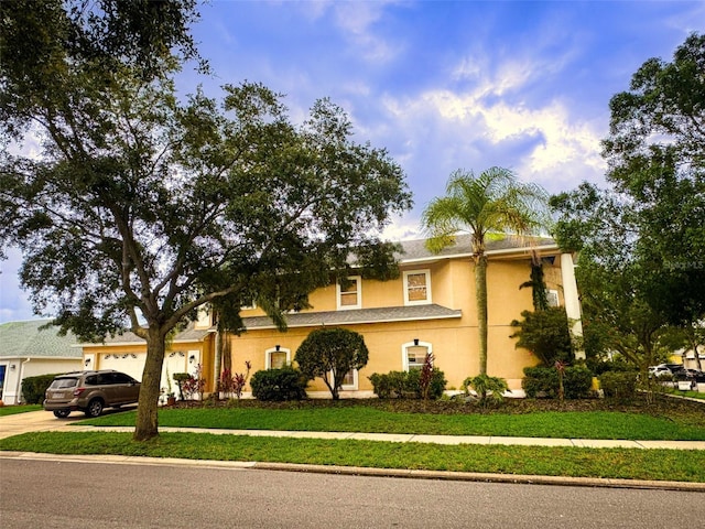 357 Fairway Pointe Cir, Orlando, FL 32828 - view of front of property featuring driveway, a garage, a front yard, and stucco siding