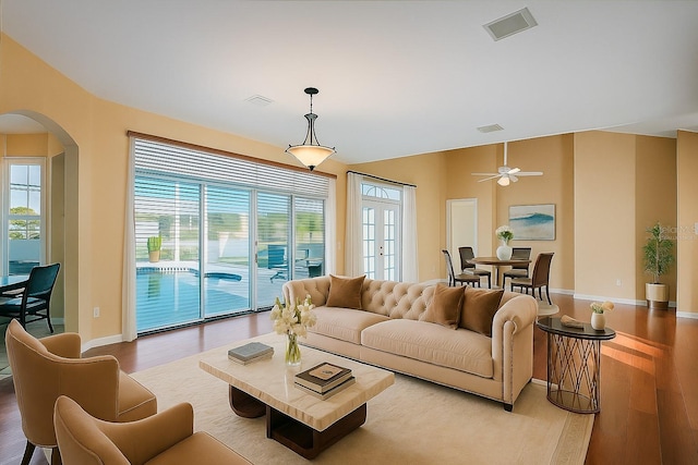 357 Fairway Pointe Cir, Orlando, FL 32828 - living room with wood finished floors, baseboards, arched walkways, plenty of natural light, and vaulted ceiling