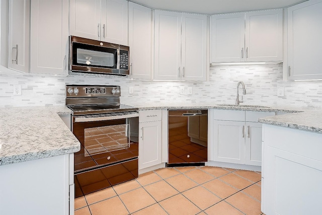 357 Fairway Pointe Cir, Orlando, FL 32828 - kitchen with black appliances, a sink, light tile patterned floors, decorative backsplash, and white cabinetry